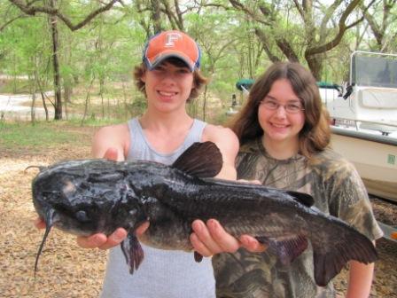 Young Boy with Girl Holding Large Bass